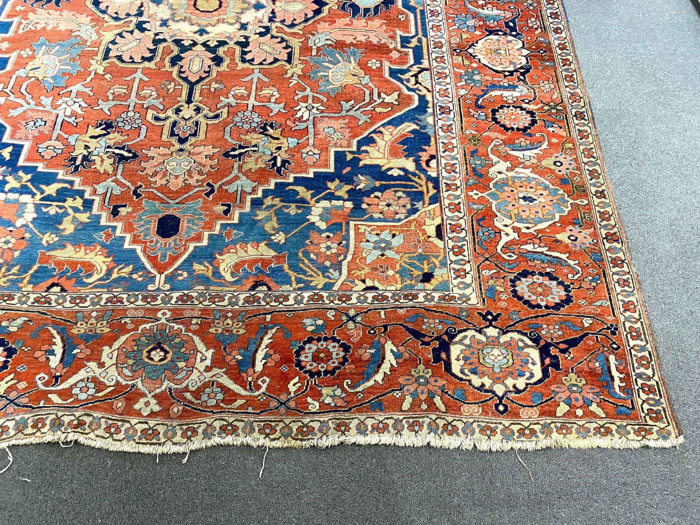 An antique Heriz brick red ground carpet, 370cm x 290cm